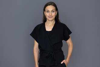 Porträttbild av statssekreterare Ulrika Hoff framför en grå bakgrund.