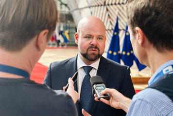 Landsbygdsminister Peter Kullgren stár framför tvár reportrar och blir intervjuad公司。