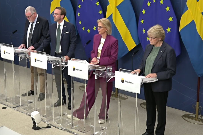 De medverkande står bakom var sin talarpulpet. Svenska flaggor i fonden.