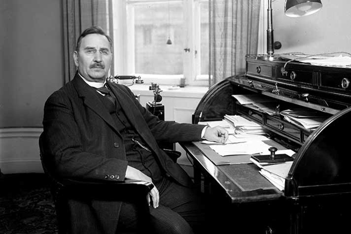 Carl Gustaf Ekman vid ett skrivbord i ett kontorsrum.