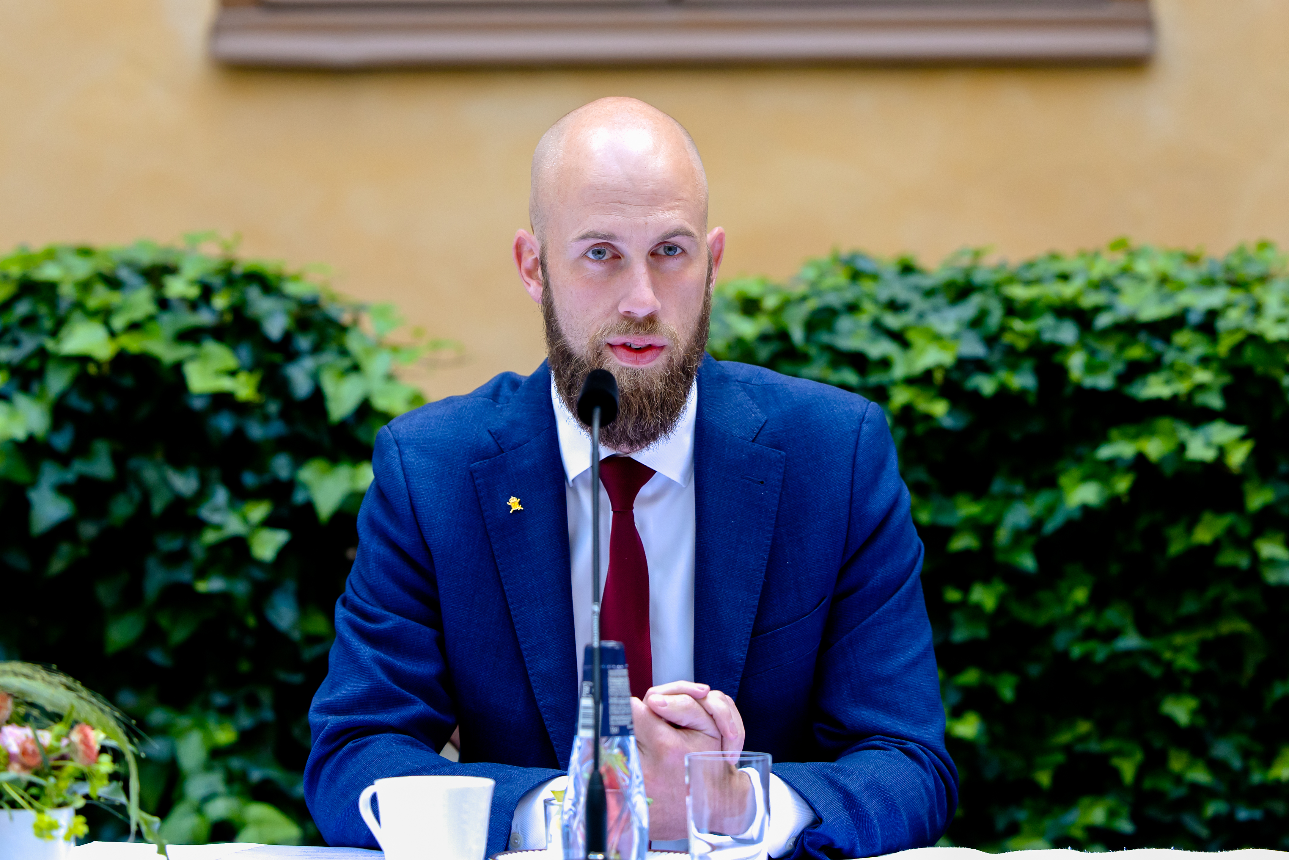 Carl-Oskar Bohlin vid ett bord med mikrofon.