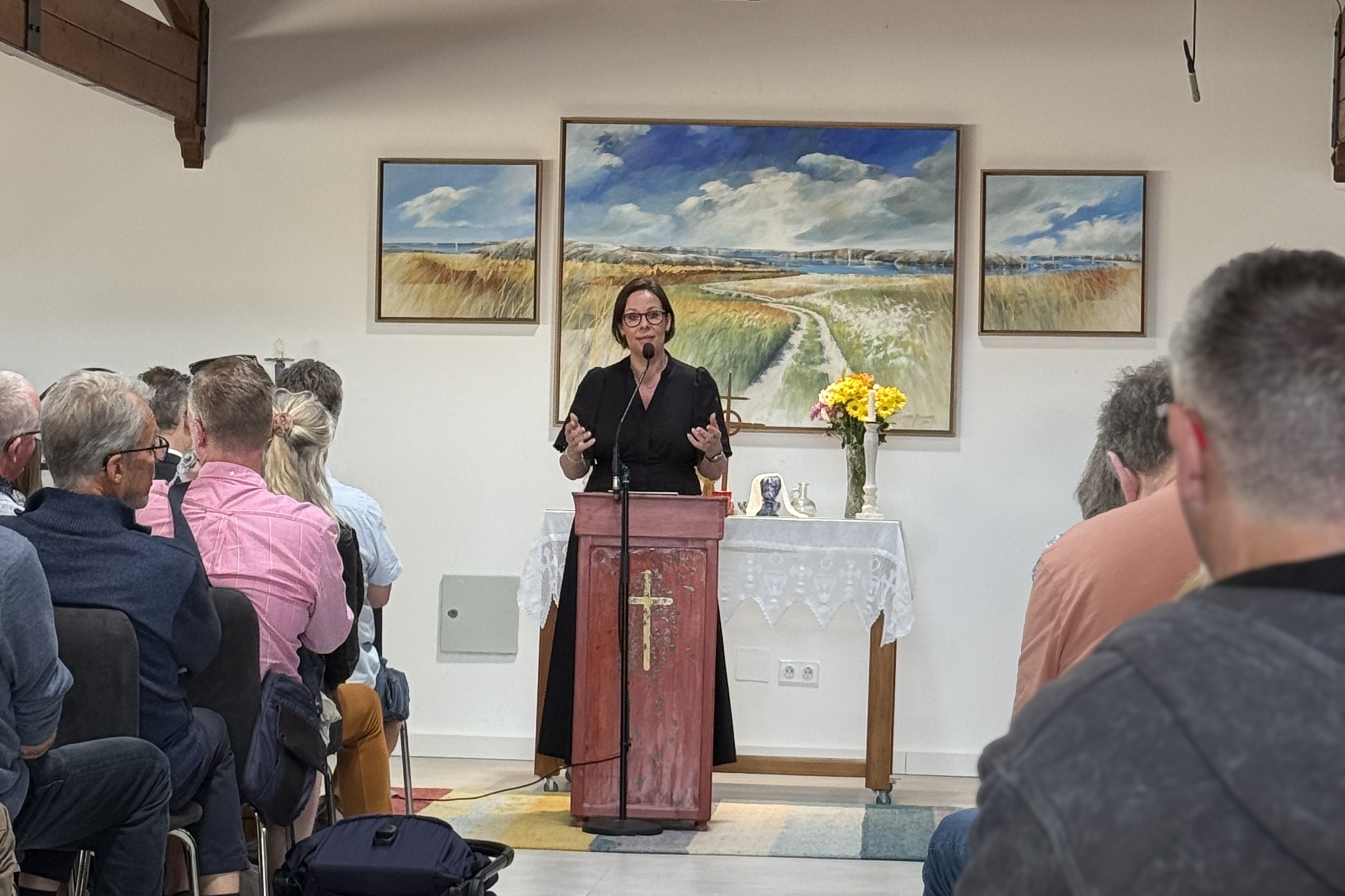 Utrikesministern står bakom en talarstol i svenska kyrkan och talar till en publik.