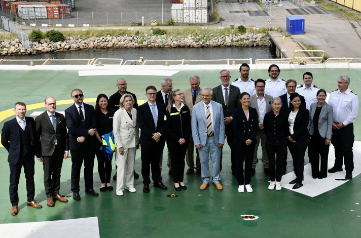 Flera personer står på däck till isbrytarfartyget Oden.