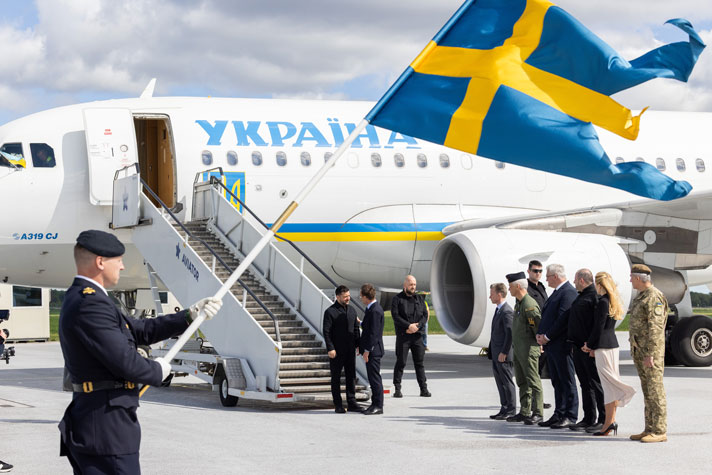 Statsministern tar emot Ukrainas president vid trappan till ett flygplan