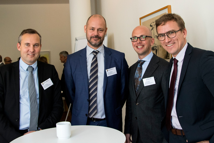 Fyra män står tillsammans runt ett bord