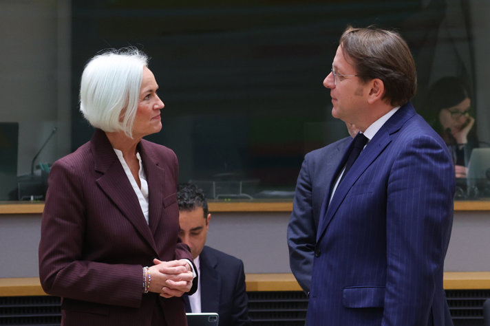 Två personer, en man och en kvinna, samtalar med varandra i en mötessal.