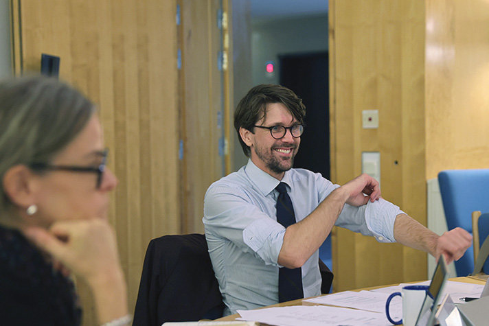 Man i skjorta sitter på ett möte