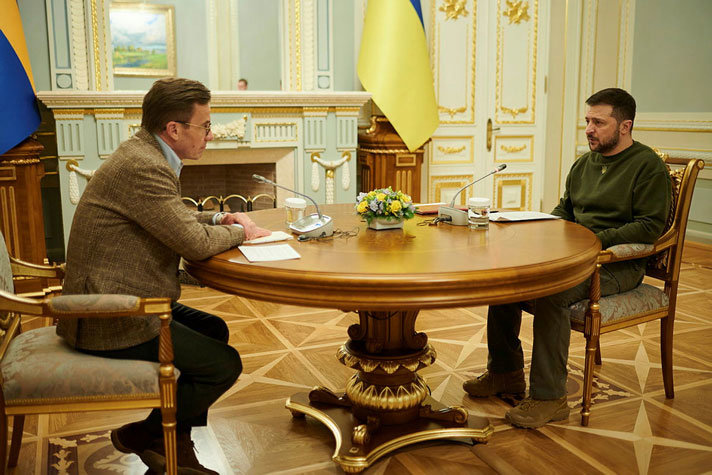 Statsminister Ulf Kristersson och Ukrainas president Volodymyr Zelenskyj sitter i var sin stol vid ett bord i Kiev.