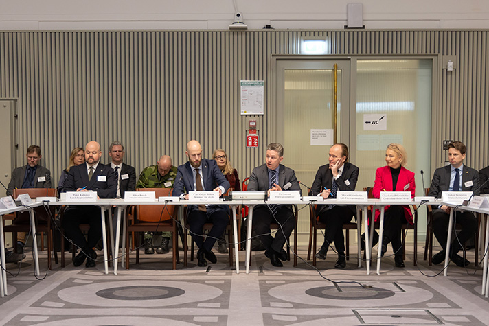 Vid ett långbord sitter politiker, Försvarsmaktens generaldirektör och MSB:s generaldirektör. 