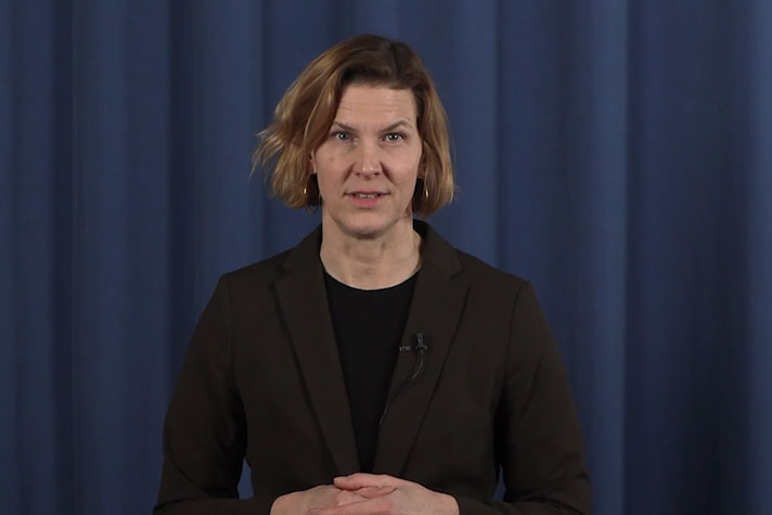 jämställdhetsminister Nina Larsson står filmad i halvfigur och talar in i kameran