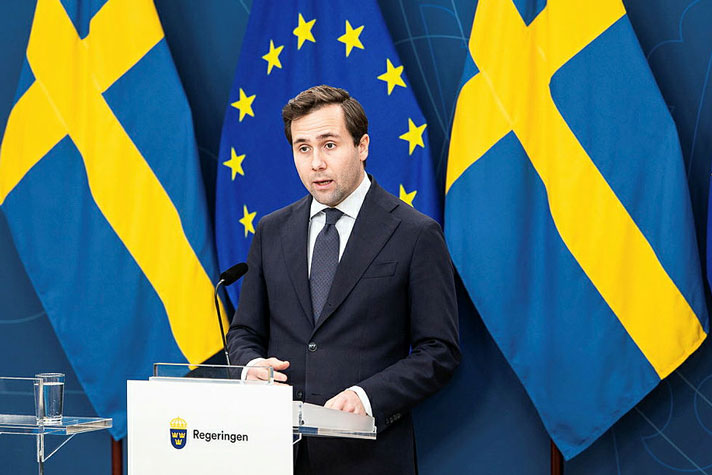 Bist&#xE5;nds- och utrikeshandelsminister Benjamin Dousa st&#xE5;r vid en talarpulpet.