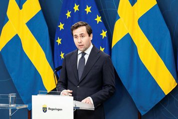 Bistånds- och utrikeshandelsminister Benjamin Dousa står vid en talarpulpet.