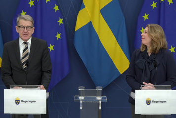 Två personer står vid var sin talarpulpet.