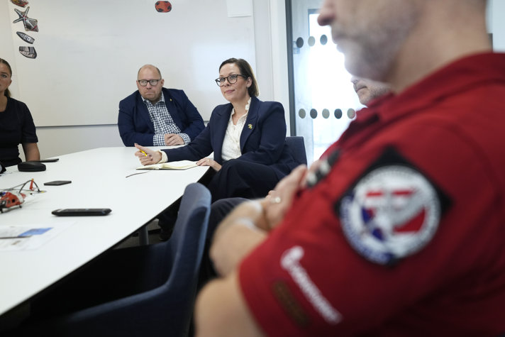 Utrikesministern sitter vid ett bord.