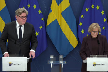 Justitieminister Gunnar Strömmer och rikspolischef Petra Lundh står vid var sin talarstol. Flaggor i fonden.