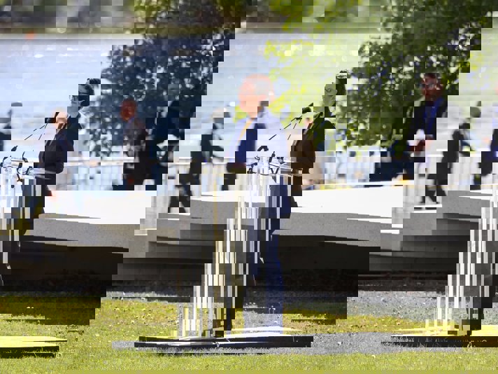 Maria Malmer Stenergard talar utomhus vid en talarstol.