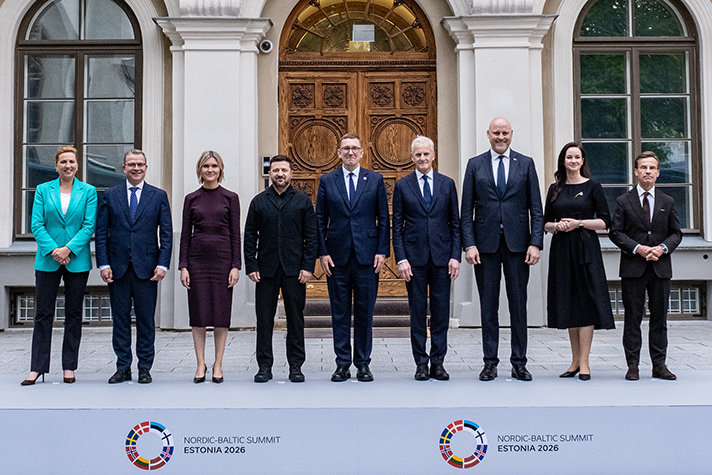De nordiska och baltiska ledarna och Ukrainas president står bredvid varandra på ett fotopodium framför en byggnad. På podiumet syns de nordiska och baltiska flaggorna samt texten "Nordic-Baltic Summit Estonia 2026".