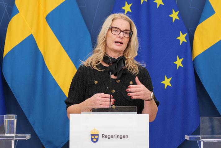 Lotta Edholm bakom en talarstol i regeringens pressrum.