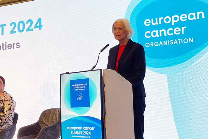 Acko Ankarberg Johansson talar bakom en talarstol, det står "European Cancer Summit" på den.