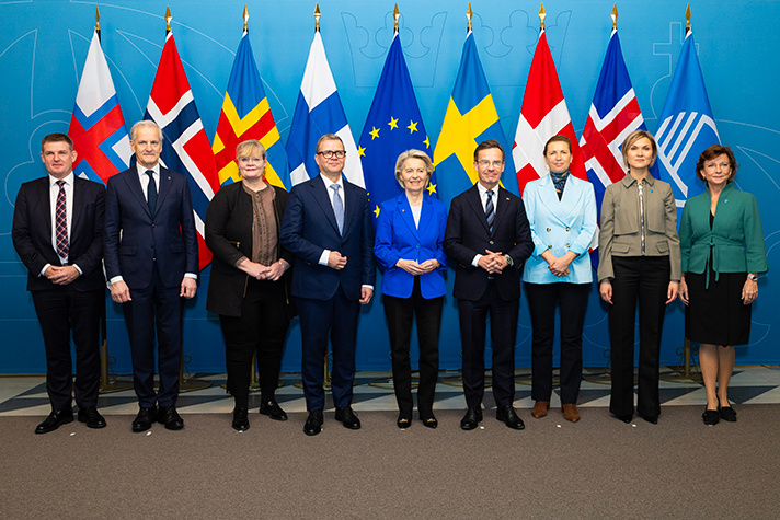 Aksel V. Johannesen, Mette Fredriksen, Ursula von der Leyen, Petteri Orpo, Ulf Kristersson, Katrin Sjögren, Jonas Gahr Støre, Kristrún Frostadóttir och Karen Ellemann står på rad inomhus mot en blå bakgrund. Bakom dem syns en rad med flaggor: Färöarna, Danmark, EU, Finland, Sverige, Åland, Norge Island, Nordiska rådet.