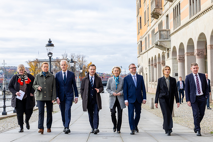 Katrin Sjögren, Mette Fredriksen, Jonas Gahr Støre, Ulf Kristersson, Ursula von der Leyen, Petteri Orpo, Kristrún Frostadóttir och Aksel V. Johannesen går bredvid varandra längs Strömgatan i Stockholm. I bakgrunden syns Rosenbad.