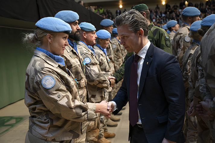 Försvarsminister Pål Jonson skakar hand med en soldat vid en ceremoni. 