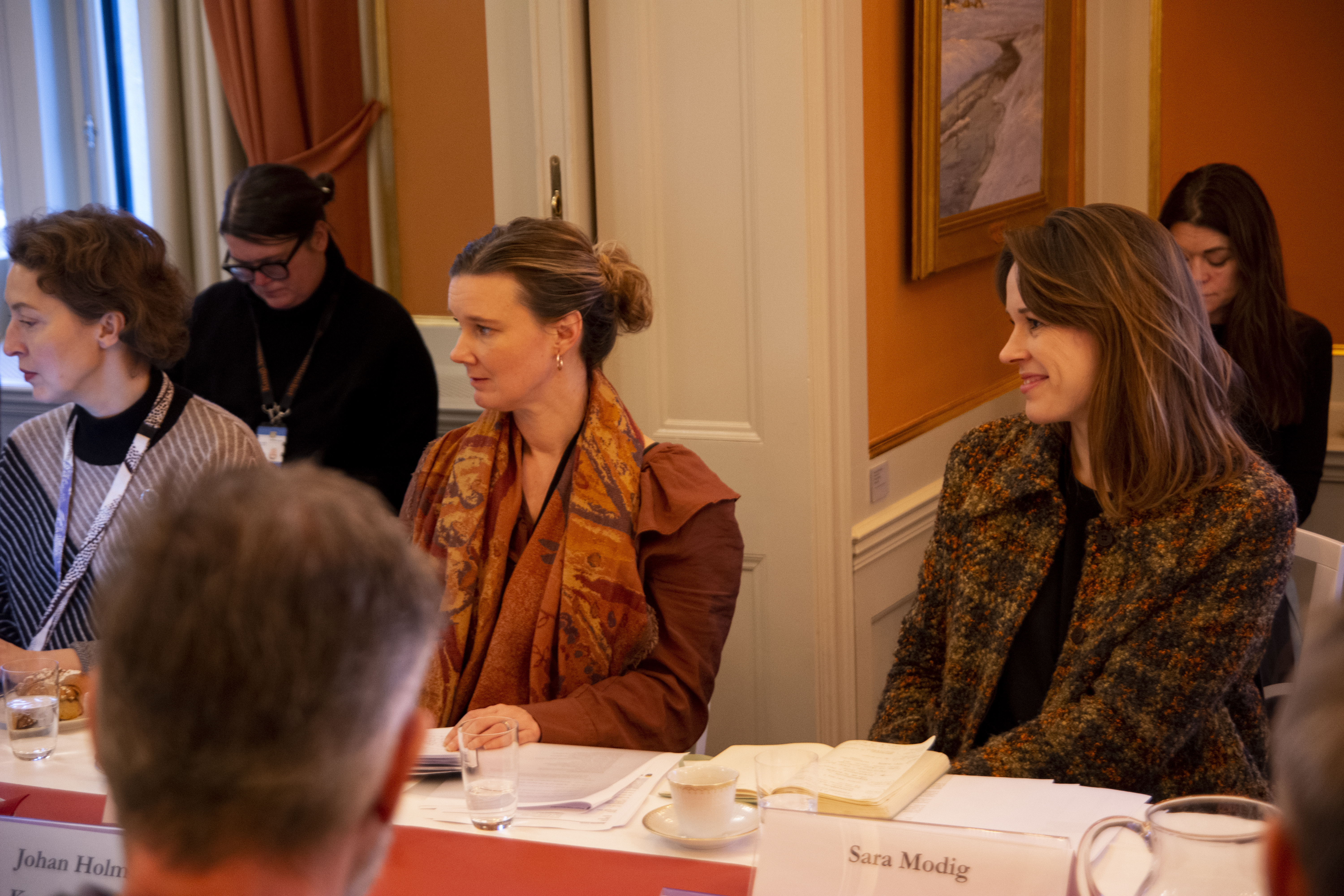 Personer sitter vid ett bord och samtalar