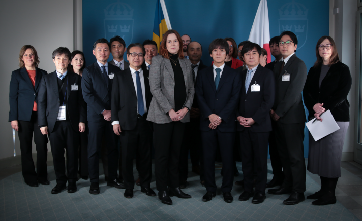 Gruppbild mot en en vägg inomhus.