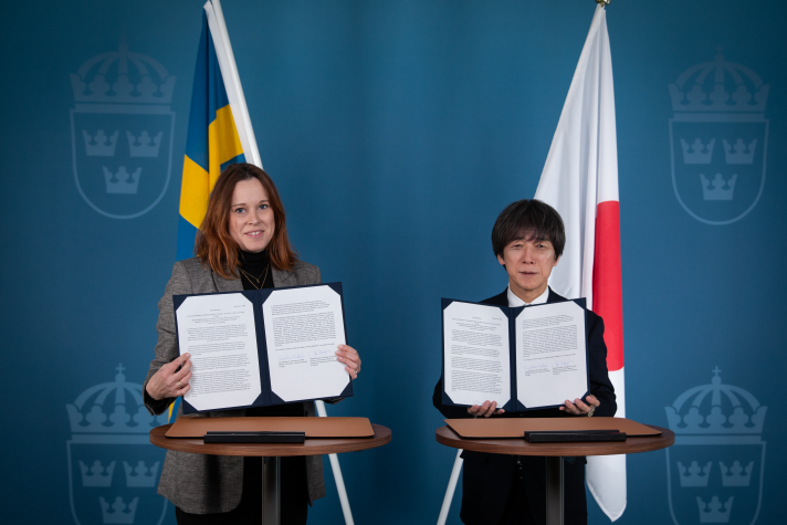 Statssekreteraren till vänster och vice-ministern håller upp varsitt exemplar av det undertecknade uttalandet,