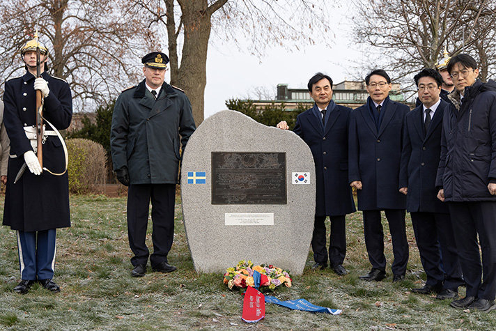 Mellan hedersvakter och strax bakom minnesstenen står en svensk brigadgeneral och försvarsminister Ahn Gyu-back.