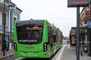 Foto på en grön elbuss i stadsmiljö