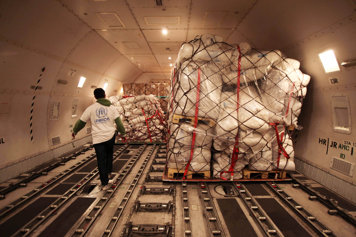 UNHCR medarbetare i ett flygplan med förnödenheter.