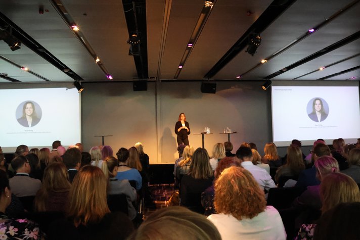 Sara Modig står på scenen och håller sin inledande presentation om förenklingspolitik inför drygt 200 personer som medverkade  under dagen