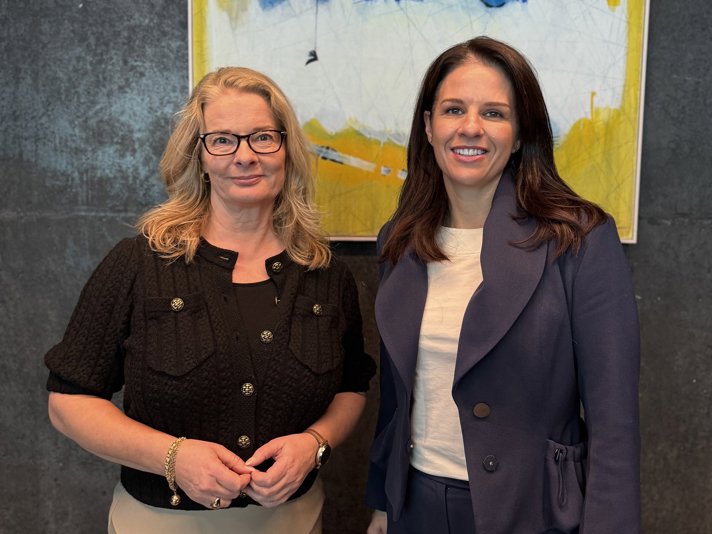 Ministrarna står framför en vägg och ler mot kameran.