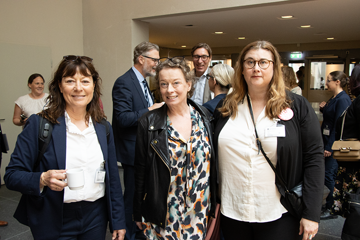 Tre personer står bredvid varandra och tittar framåt.