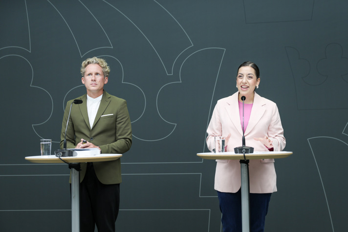 Särskilde utredare Mathias Wahlsten och Simona Mohamsson står bakom varsina talarstolar.