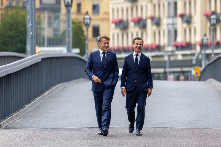 Emmanuel Macron och Ulf Kristersson går bredvid varandra på Skeppsholmen i Stockholm.