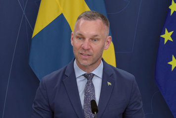 Civilminister Erik Slottner i halvfigur vid en talarpulpet.