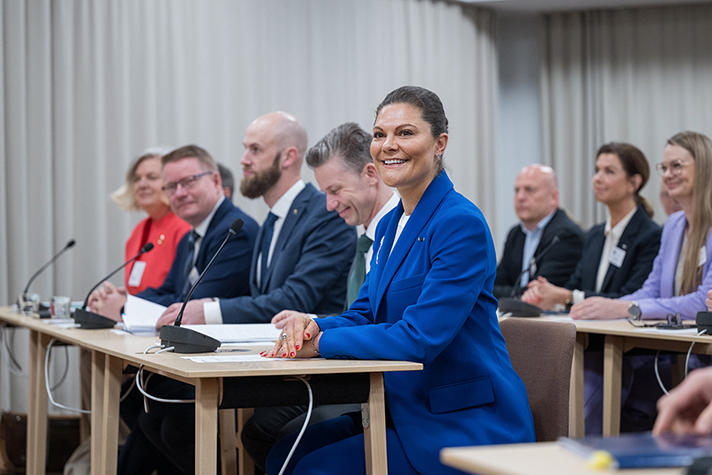 Kronprinsessan Victoria sitter med statsråden Carl-Oskar Bohlin och Pål Jonson vid ett bord på Hanaholmen utanför Helsingfors.