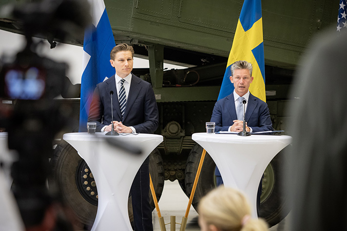 Finlands försvarsminister Antti Häkkänen och försvarsminister Pål Jonson står bredvid varandra bakom ett bord.