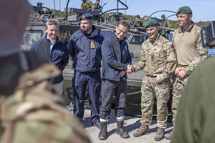Statsminister Ulf Kristersson och Pål Jonson hälsar på befäl ur Royal Marines. 