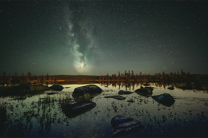 Landskapsbild med utblick mot rymden över Pärlälven i Jokkmokk.