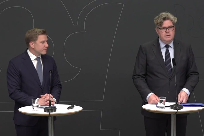 De två medverkande står vid var sin talarpulpet.