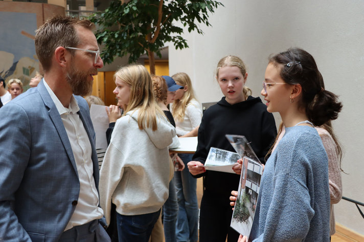 Socialminister Jakob Forssmed pratar med en flicka.