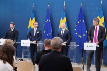 Finansmarknadsminister Niklas Wykman och infrastruktur- och bostadsminister Andreas Carlson, Oscar Sjöstedt (SD), och Patrik Karlson (L) står på en scen framför församlade journalister.