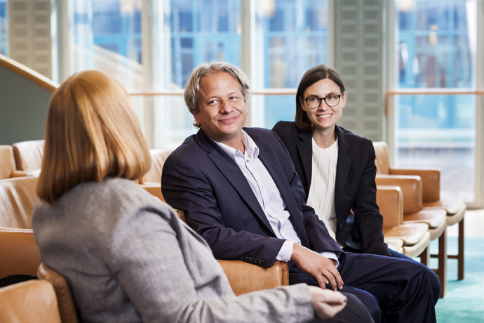 Två kvinnor och en man sitter och samtalar.