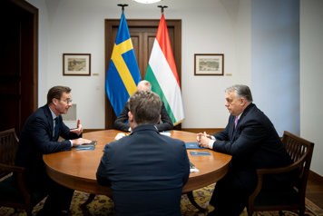 Statminister Ulf Kristersson och premiärminister Viktor Orbán sitter mitt emot varandra vid ett runt bord..