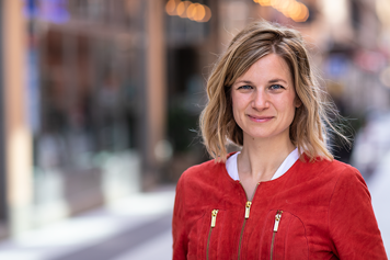 Bild på Fanny von Heland i röd jacka på en gata.