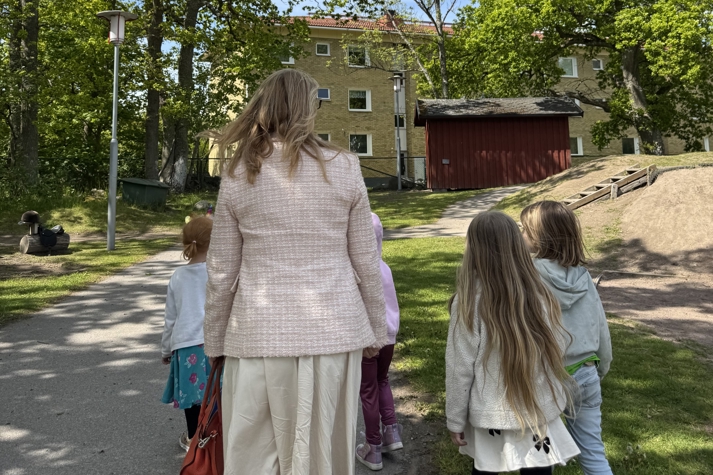 Skolministern och några barn är på en skolgård