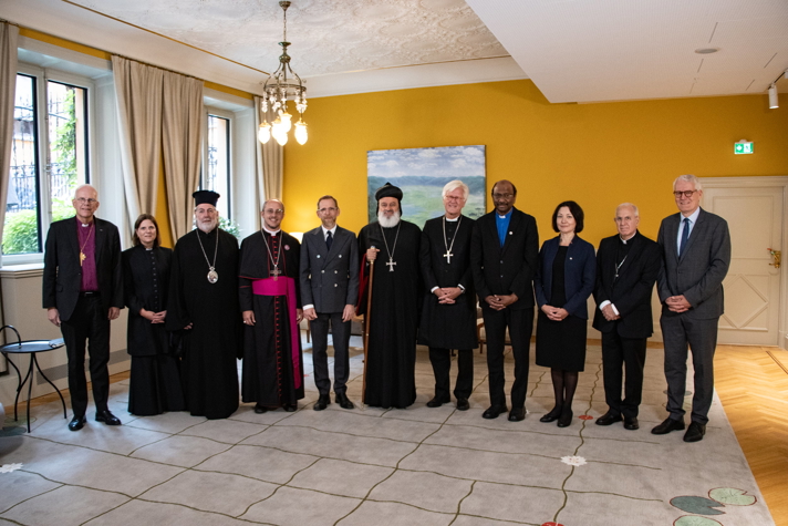 Gruppbild på elva personer i olika religiösa klädedräkter.